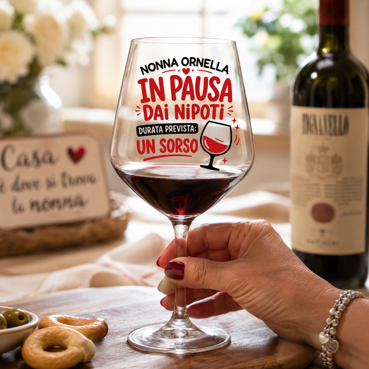 Calice da vino con scritta «In pausa dai nipoti» e nome, tenuto da una mano