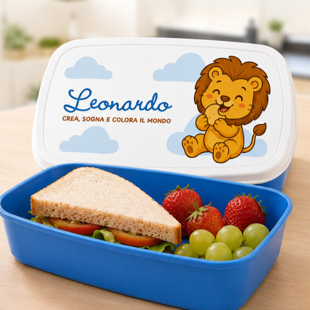 Scatola pranzo personalizzata blu aperta con panino e frutta nel contenitore