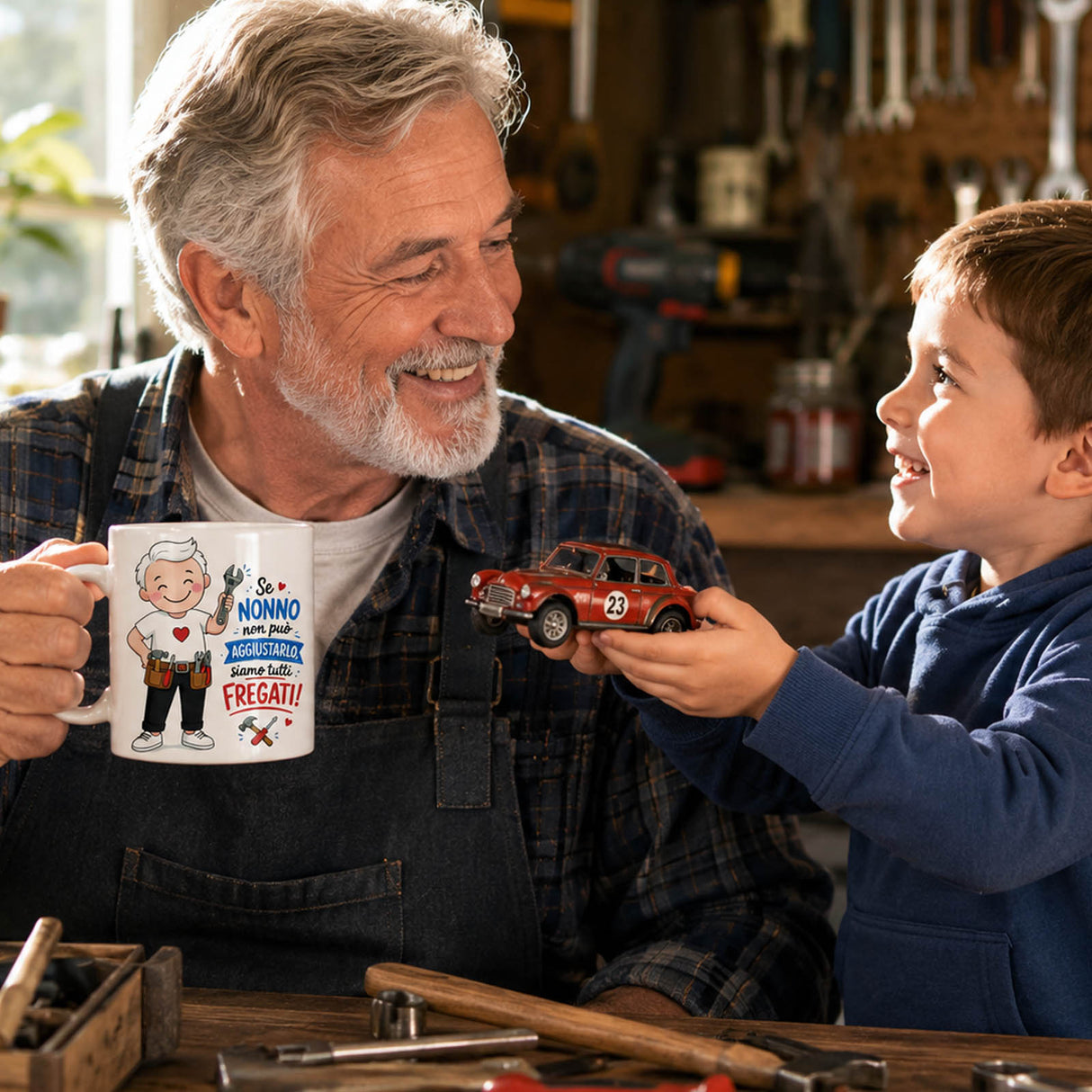 Tazza bianca con grafica del nonno, bimbo la mostra accanto in officina.