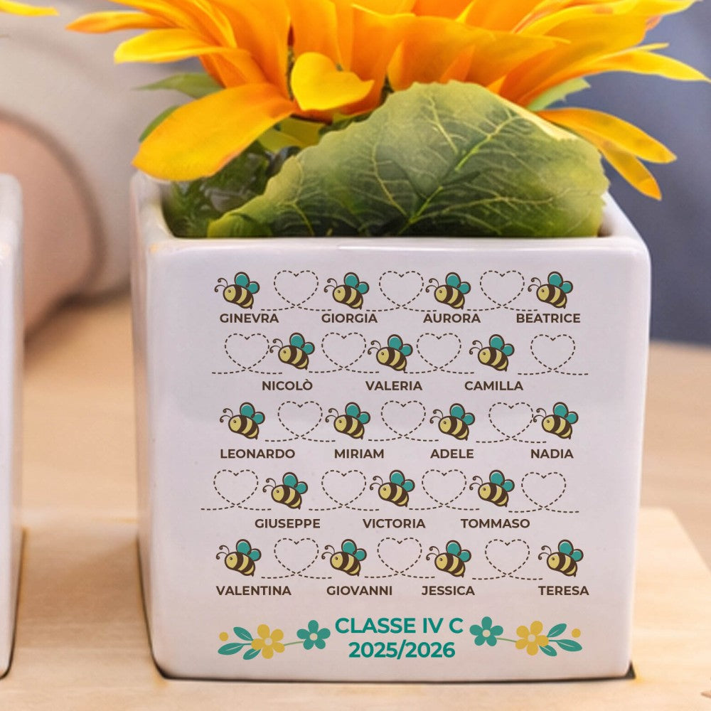 Vasetto bianco con fiori gialli, elenco nomi e 'CLASSE IV C 2025/2026' con api