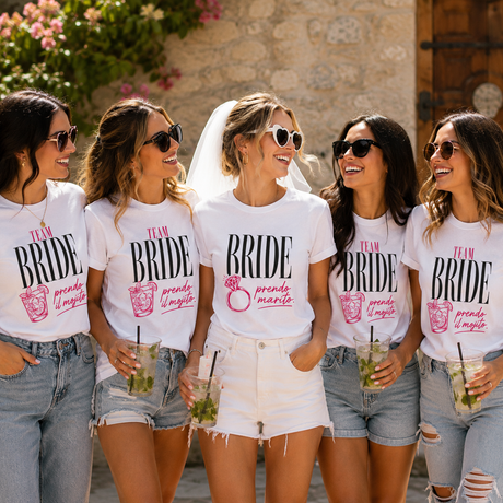 T-shirt bianche con scritta “TEAM BRIDE” e “prendo marito” rosa, indossate in gruppo.
