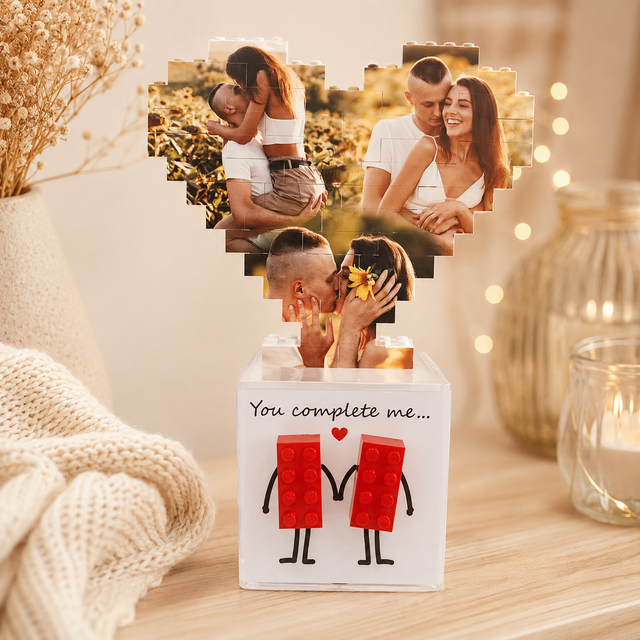 Cuore di foto in mattoncini sopra scatola bianca con figure rosse e base in plexi