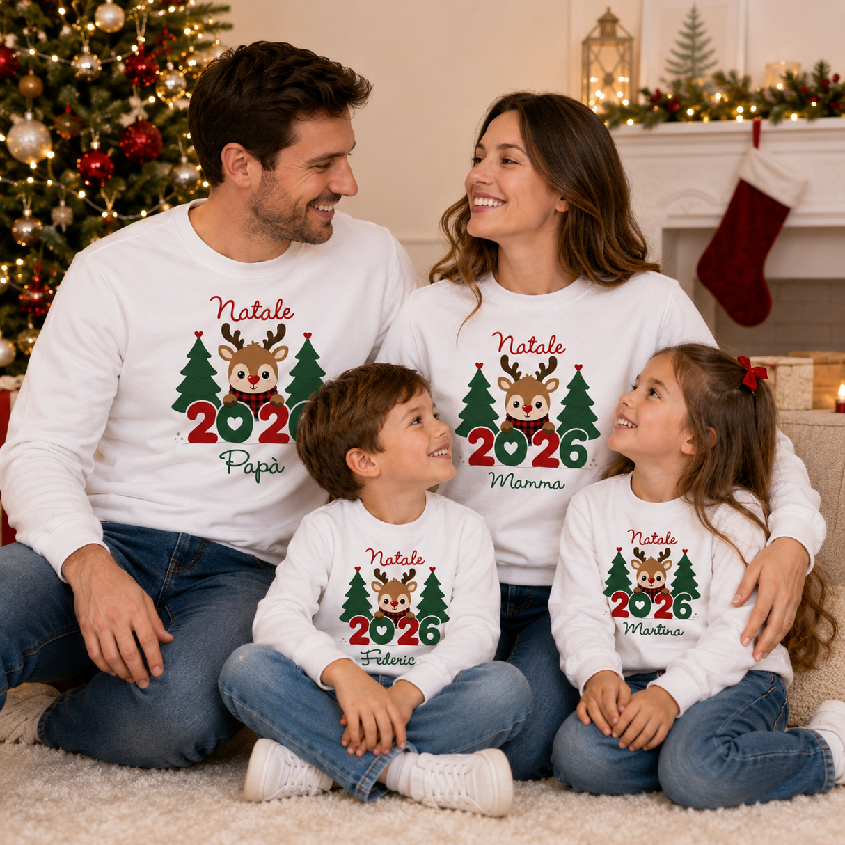 Famiglia in felpe bianche Natale 2026 con renne e alberi, scritte Papà/Mamma
