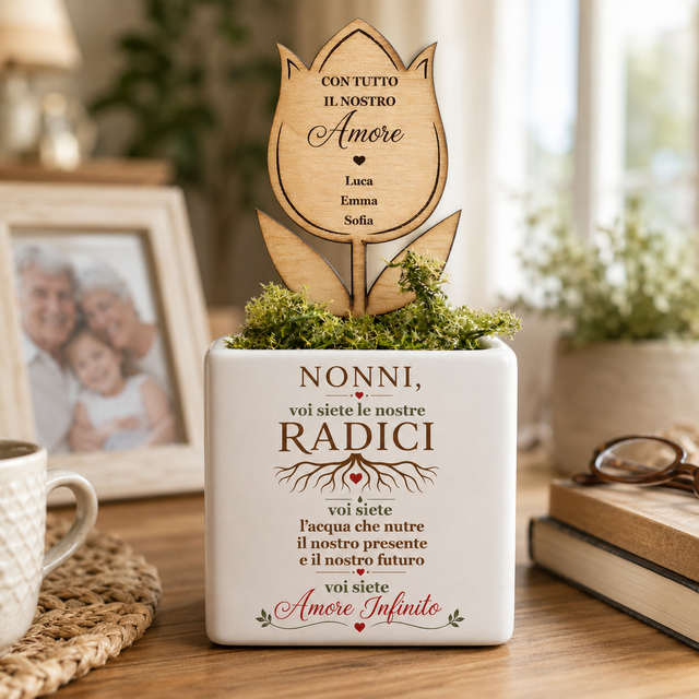 Vaso bianco con fiore in legno inciso e scritta “Nonni, voi siete le nostre radici”.