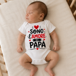 Body neonato bianco indossato con grafica “Sono l’amore di papà” e cuori rossi