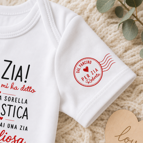 Body neonato bianco a maniche corte con patch rossa e parte della scritta “Ciao Zia!”