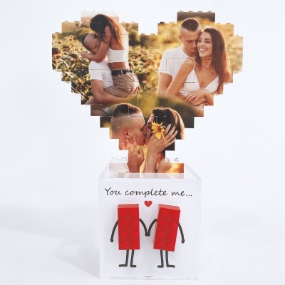 Cuore di foto in mattoncini sopra scatola bianca con scritta e due figure rosse