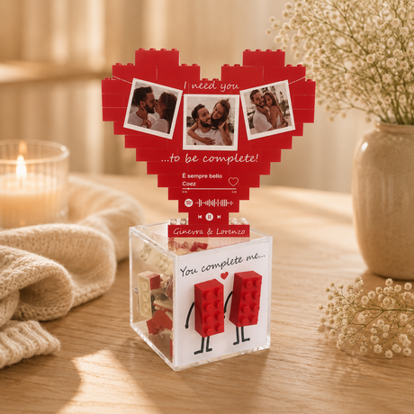 Cuore di mattoncini rosso con tre foto incorniciate, su supporto trasparente