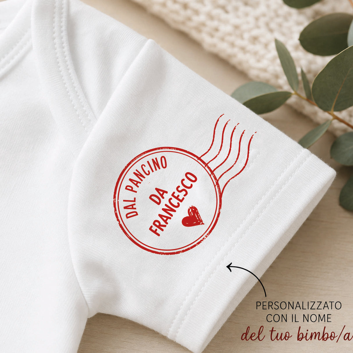 Body neonato bianco con logo rosso circolare e testo sul polsino