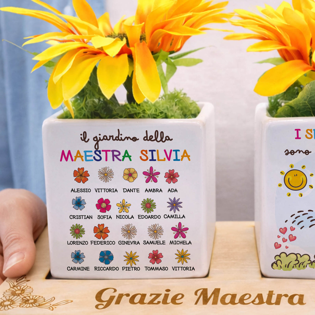 Vasetto bianco personalizzato con scritta Il giardino della Maestra Silvia e fiori arancioni