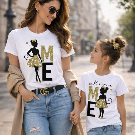 T-shirt bianca con stampa glitter oro: lettere M ed E e sagoma stilizzata