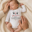 Body neonato bianco a maniche lunghe con stampa cuore e impronte, indossato