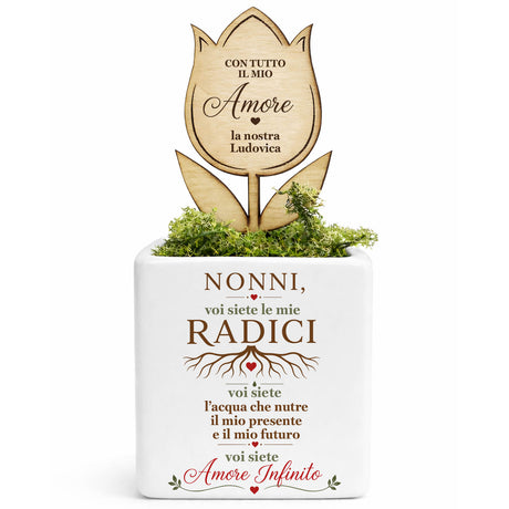 Vaso bianco con fiore in legno inciso e scritta “Nonni, voi siete le mie radici”.
