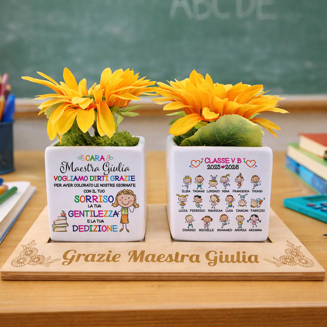 Due vasetti bianchi con fiori gialli e vassoio con incisione “Grazie Maestra Giulia”