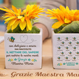 Vasetto bianco con fiori gialli, frase 'con dedizione e amore' e api con cuori